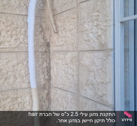 צינור מיזוג אוויר עטוף ליד קיר אבן